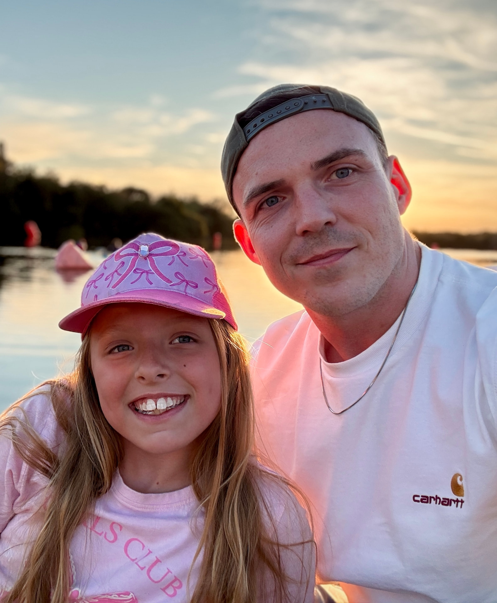 Daniel Betts, founder of Musette, with his daughter by a lake at sunset